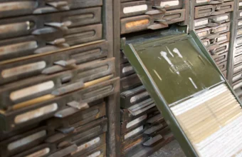 A vintage Kardex card-index filing cabinet with one drawer pulled open, exposing rows of index cards