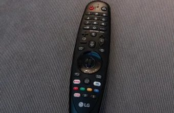 An LG Android TV remote lying on a fabric surface, showing dedicated Netflix and Prime Video buttons alongside colored quick-access buttons