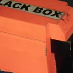 An orange flight data recorder, or black box, on display at an aviation museum