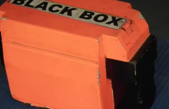 An orange flight data recorder, or black box, on display at an aviation museum