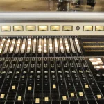 A vintage 20-channel Stax Records mixing console with illuminated faders and VU meters, a visual metaphor for tuning many parameters at once