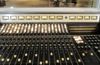 A vintage 20-channel Stax Records mixing console with illuminated faders and VU meters, a visual metaphor for tuning many parameters at once