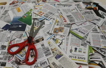 A pile of grocery coupons with a pair of red-handled scissors, representing the discount Meta offers developers who share their AI usage data