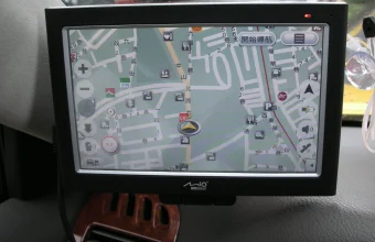A windshield-mounted GPS navigation device showing a live map with a location marker, illustrating real-time location tracking