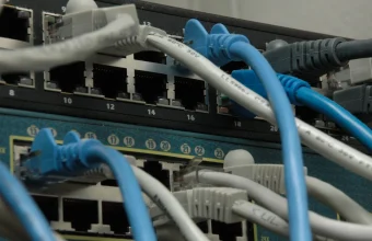 Two enterprise network switches with CAT5 Ethernet cables plugged into their ports