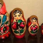 Six Russian nesting dolls (matryoshka) lined up from largest to smallest against a plain wall