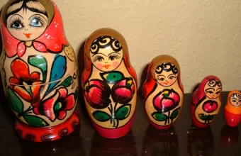 Six Russian nesting dolls (matryoshka) lined up from largest to smallest against a plain wall