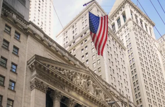 The New York Stock Exchange building facade with a large American flag, where Nscale plans to list its shares