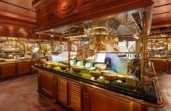 An elaborate all-you-can-eat buffet counter with ornate brass fixtures and small bowls of food arranged along a glass display case