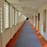 A long hotel corridor with a row of near-identical numbered doors, evoking the mix-up between a fictional test target and a real company