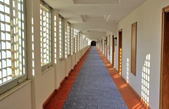 A long hotel corridor with a row of near-identical numbered doors, evoking the mix-up between a fictional test target and a real company