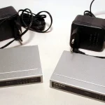 Two Zyxel network switches with power adapters on a white background
