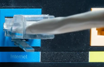 Gray Ethernet cable plugged into a blue router port labeled Internet