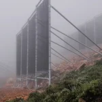 Rows of tall fog-collection nets on a misty hillside, a passive way to harvest water from air