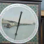 Painted auction clock with a black pointer sweeping a ring of numbers, beside a board of numbered buttons