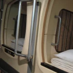 Kubernetes Node Swap Turns Idle Agent Memory Into a Density Bet With No Wake-Up Test Row of capsule hotel pods with white pillows and folded blankets, each capsule an idle sleeper packed into a shared rack