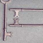 Four antique skeleton keys laid on a gray textured surface