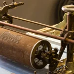A dandy roll, the screen-covered cylinder that presses a watermark pattern into paper pulp, on a paper machine at the Deutsches Technikmuseum in Berlin
