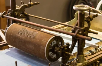 A dandy roll, the screen-covered cylinder that presses a watermark pattern into paper pulp, on a paper machine at the Deutsches Technikmuseum in Berlin