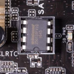 A socketed 8-pin SPI flash chip on a motherboard, the kind of part that holds UEFI firmware, beside the CLRTC and SB PWR markings