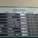 A split-flap arrivals board at Łódź Kaliska railway station in Poland listing trains by time and platform, a picture of a fixed timetable