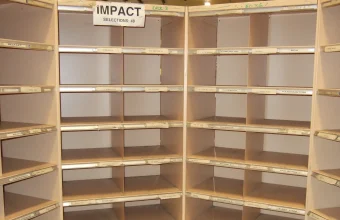 Empty wooden mail sorting frame with rows of labeled pigeonholes, like a row of boxes standing in for a memory buffer