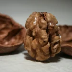 A walnut kernel standing upright between the two halves of its cracked shell, a visual pun on the Linux kernel and its shell