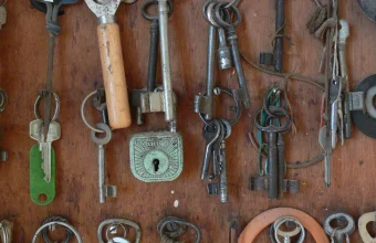 A wooden board hung with dozens of old keys on rings and key tags
