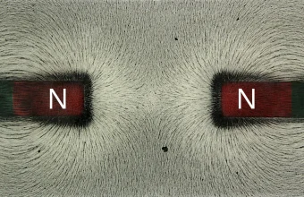 Iron filings tracing the magnetic field between two bar magnets with their north poles facing each other, a nod to the Magnetar name