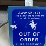 An out-of-order sign standing in an airport sink basin, with a title, a friendly explanation and a Spanish translation, like the members of an error response