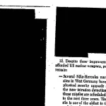 A declassified document page with large black redaction blocks covering most of the text