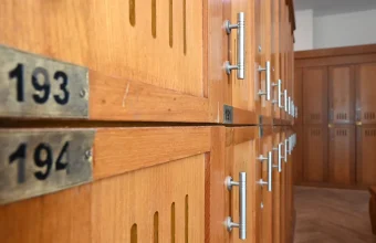 Rows of numbered wooden lockers with metal handles, with plates 193 and 194 in the foreground
