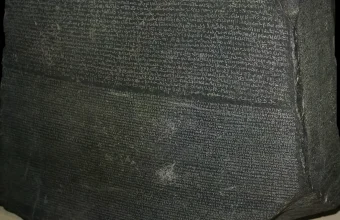 Close-up of the Rosetta Stone showing the Demotic script above and the Greek script below, the same text written in two different scripts