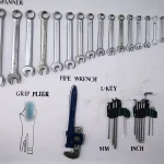 A white workshop shadow board with outlined spanners, pliers, a pipe wrench and hex keys, where an empty outline marks a tool that is missing