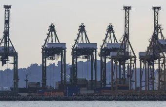 Silhouetted container gantry cranes lined up along a cargo terminal in Singapore