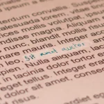 Printed page of text with a white strip of correction fluid and a handwritten correction in blue ink