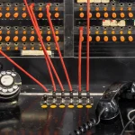 Microsoft’s Agent Lightning v1.0 Turns Agent Training Into a Sample-Accounting Problem Close-up of a vintage Western Electric manual telephone switchboard with orange lamps, red patch cords plugged into jacks, a rotary dial and a black handset