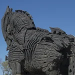 Weathered wooden replica of the Trojan horse standing against a clear blue sky on the Çanakkale waterfront in Turkey